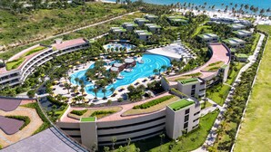 Un complexe hôtelier doté d’une piscine centrale, de plusieurs bâtiments abritant les chambres et d’une plage.