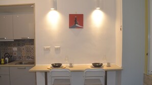 Una cocina pequeña con dos taburetes, un fregadero y un salpicadero de azulejos.