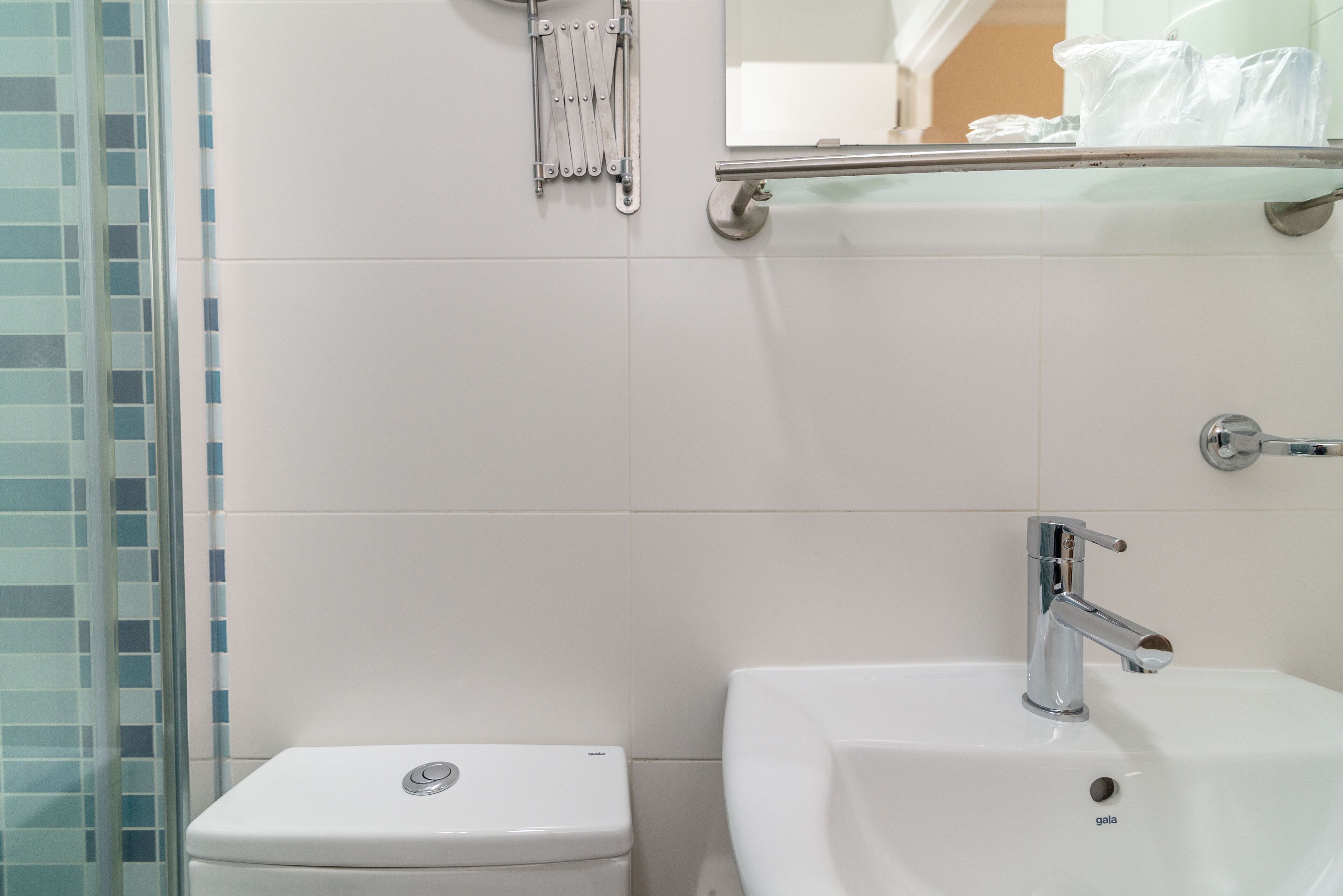 A bathroom with a toilet, a sink, and a glass shower enclosure.