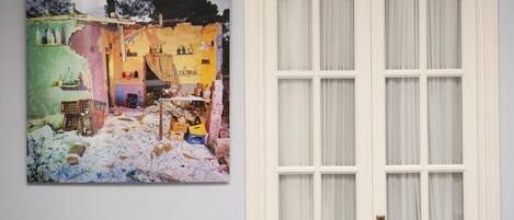 Une pièce avec une porte blanche et un tableau coloré accroché au mur.