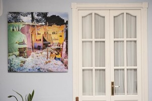 Una habitación con una puerta blanca y un cuadro colorido en la pared.