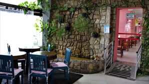 Ein Restaurant mit Stehwänden, Zimmerpflanzen und einer Treppe, die in ein Obergeschoss führt.