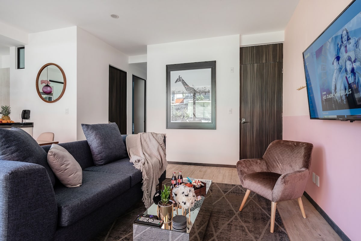 Ein modernes Wohnzimmer mit einem dunkelblauen Sofa, einem braunen Sessel und einem Couchtisch mit Dekoration.