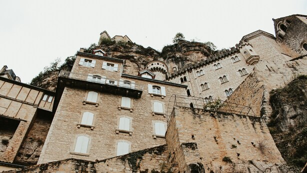 A historic stone building with multiple windows and a turret. - Accès Piscine, Fitness, Sauna ! Maisonnette Climatisée avec Terrasse (Gramat)