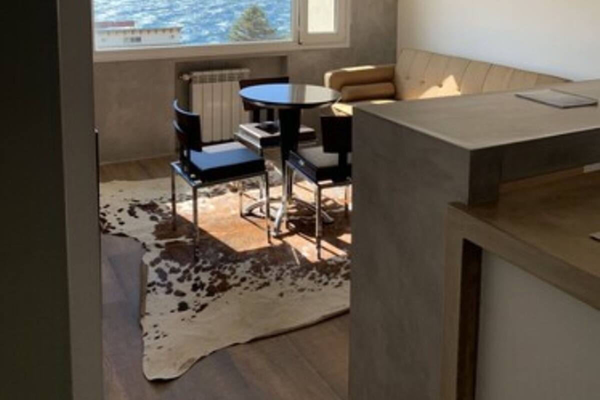 Una cocina moderna con un amplio ventanal con vista a un cuerpo de agua.