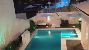 Una piscina al aire libre, tumbonas