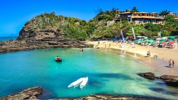 Un complejo turístico costero con aguas turquesas cristalinas, acantilados rocosos y una playa de arena.