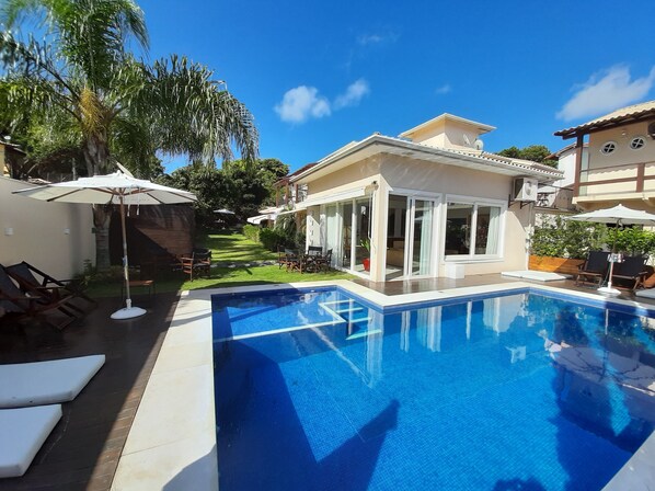 Una piscina al aire libre, tumbonas