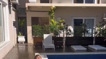 Een buitenzwembad en ligstoelen