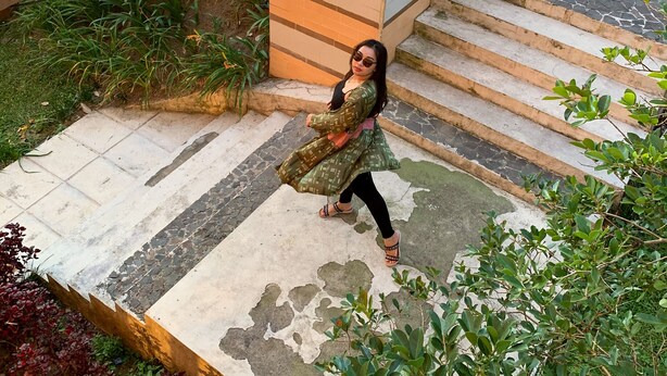 A staircase with a stone railing and a person walking down. - Tangko Inn Resort (Cipanas)
