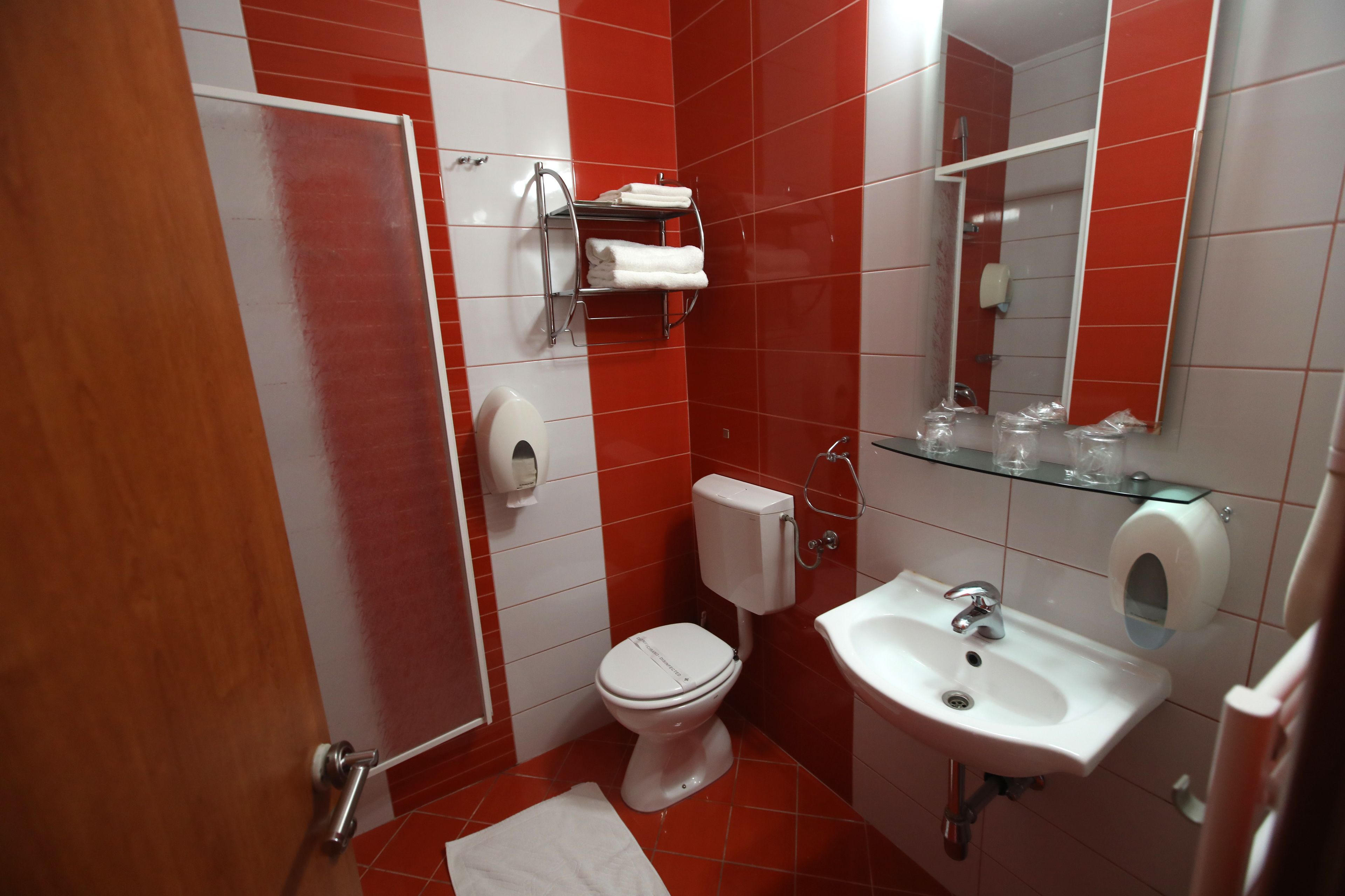 Un baño con inodoro, lavamanos y espejo.
