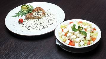 A plate with grilled chicken and a bowl of salad.