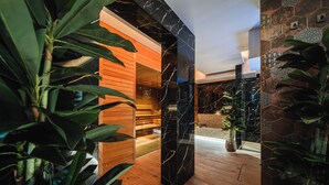 Um interior moderno com uma receção de madeira, um pilar de mármore preto e uma parede revestida com padrões geométricos.