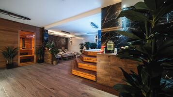 Un interior moderno con suelo de madera, una escalera y una zona de estar con cojines.