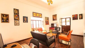 A furnished living room with a desk, computer, and multiple chairs. - We are Hostal CasArte Takubamba where you can rest an enjoy! (Sucre, Bolivia)
