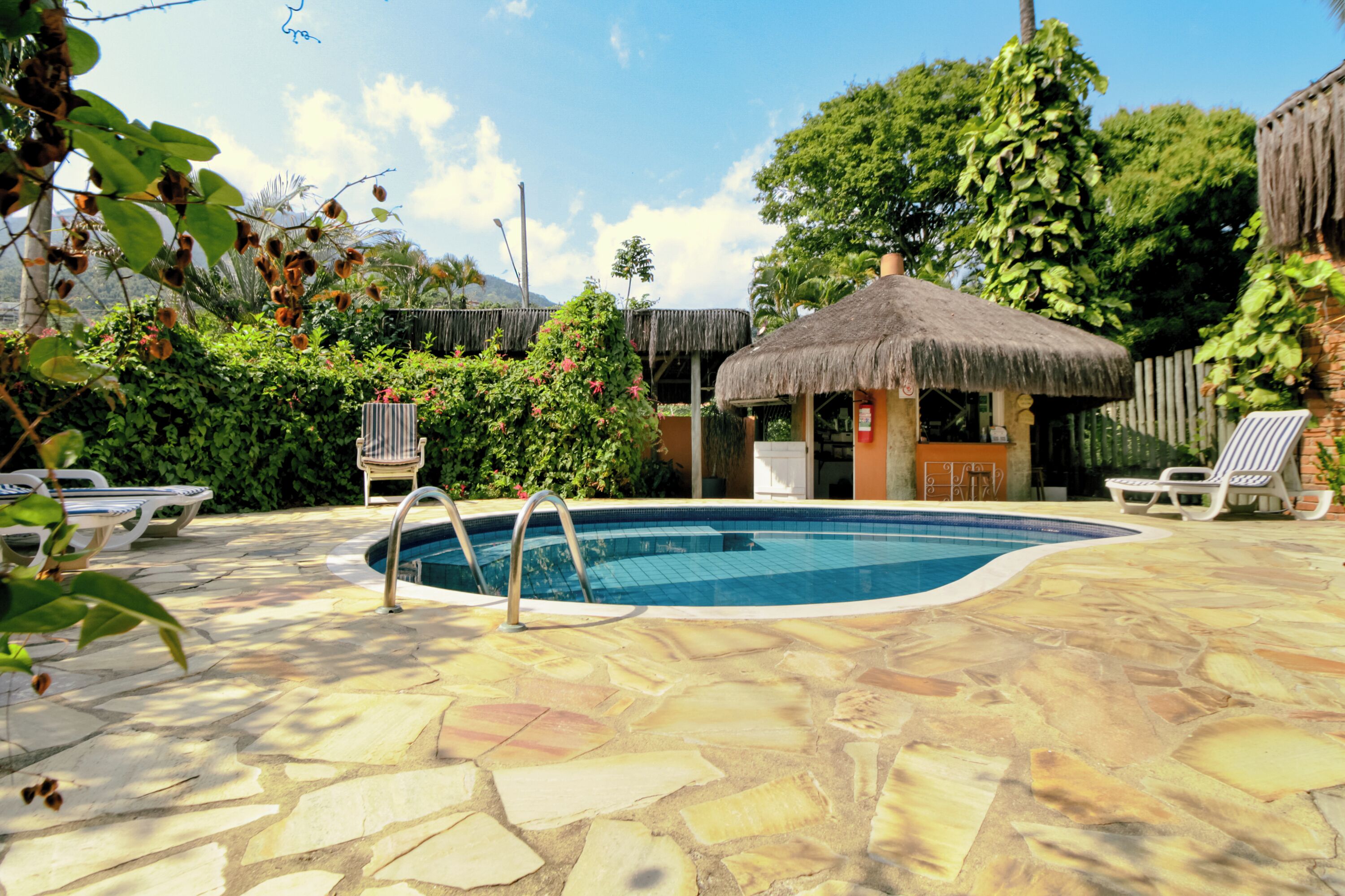 Una piscina al aire libre, sillones reclinables de piscina