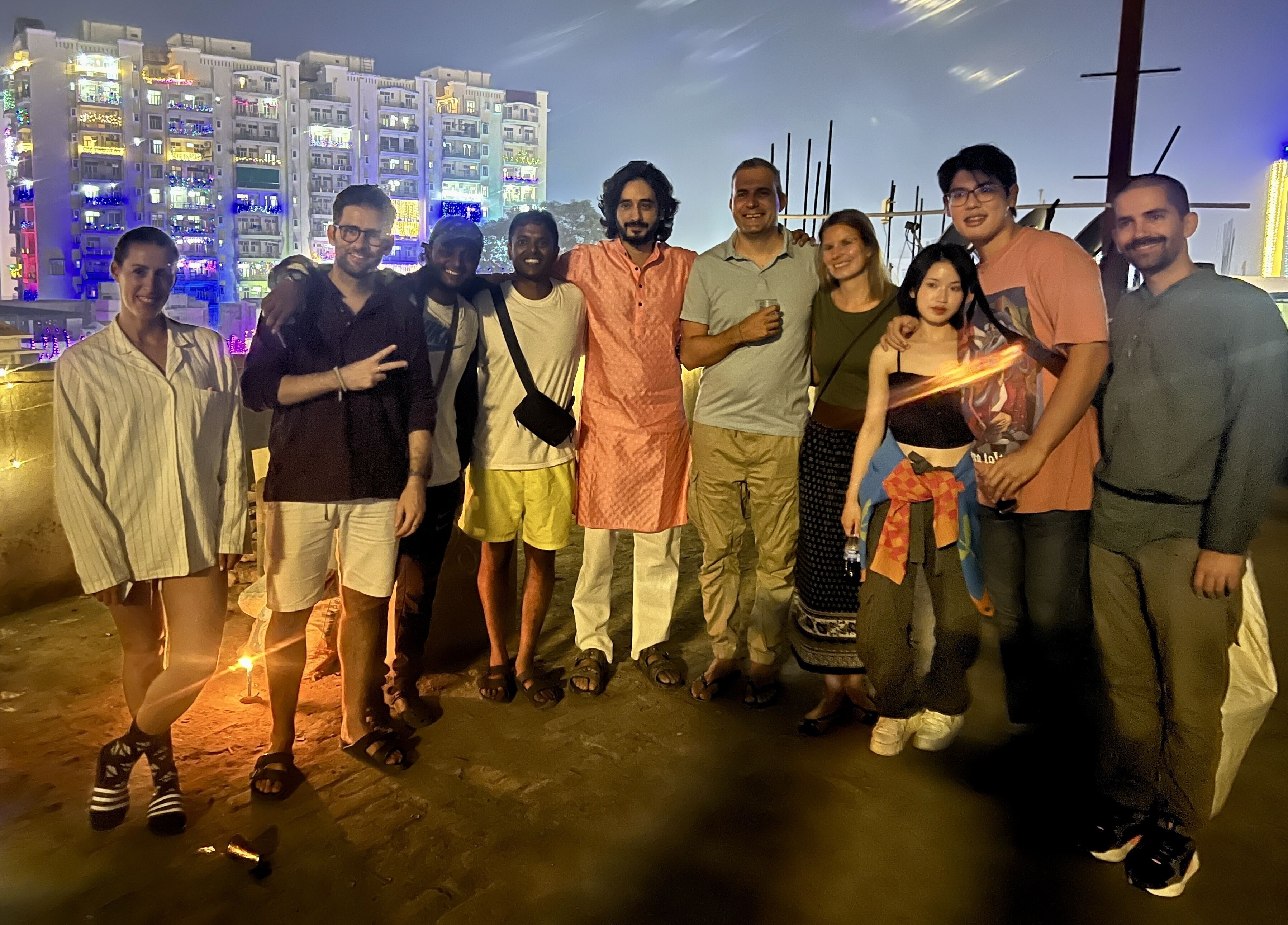 A group of people standing on a balcony with a cityscape in the background.
