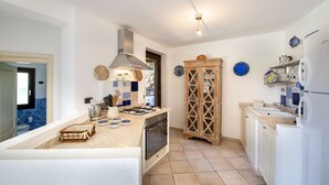 A kitchen with a gas stove, oven, and a wooden cabinet.
