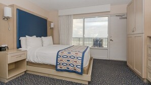 A hotel room with a bed, a nightstand, a wardrobe, and a window with a view.