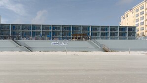 A multi-story building with a sign reading 'DOLPHIN BEACH CLUB'.