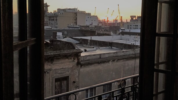 A view from a window overlooking a cityscape with buildings and cranes, suggesting an urban environment. - Spacious illuminated and unique apartment (Montevideo)
