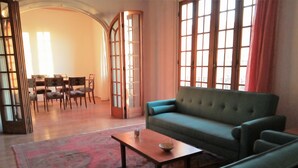 A living room with a sofa, a coffee table, and a dining area with chairs and a table. - Spacious illuminated and unique apartment (Montevideo)