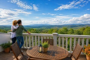 A couple embracing on a balcony overlooking a scenic landscape with mountains in the distance. - Panoramic Terrace, Sunsets, Nature and Stargazing in the Sierra de Béjar (Navalmoral)