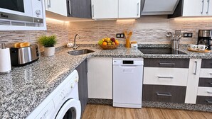A modern kitchen with a built-in microwave, toaster, sink, and dishwasher. - Panoramic Terrace, Sunsets, Nature and Stargazing in the Sierra de Béjar (Navalmoral)