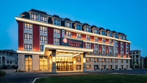 A multi-story hotel with a prominent entrance and signage. - Ramada by Wyndham Zhenjiang City Center (Zhenjiang)