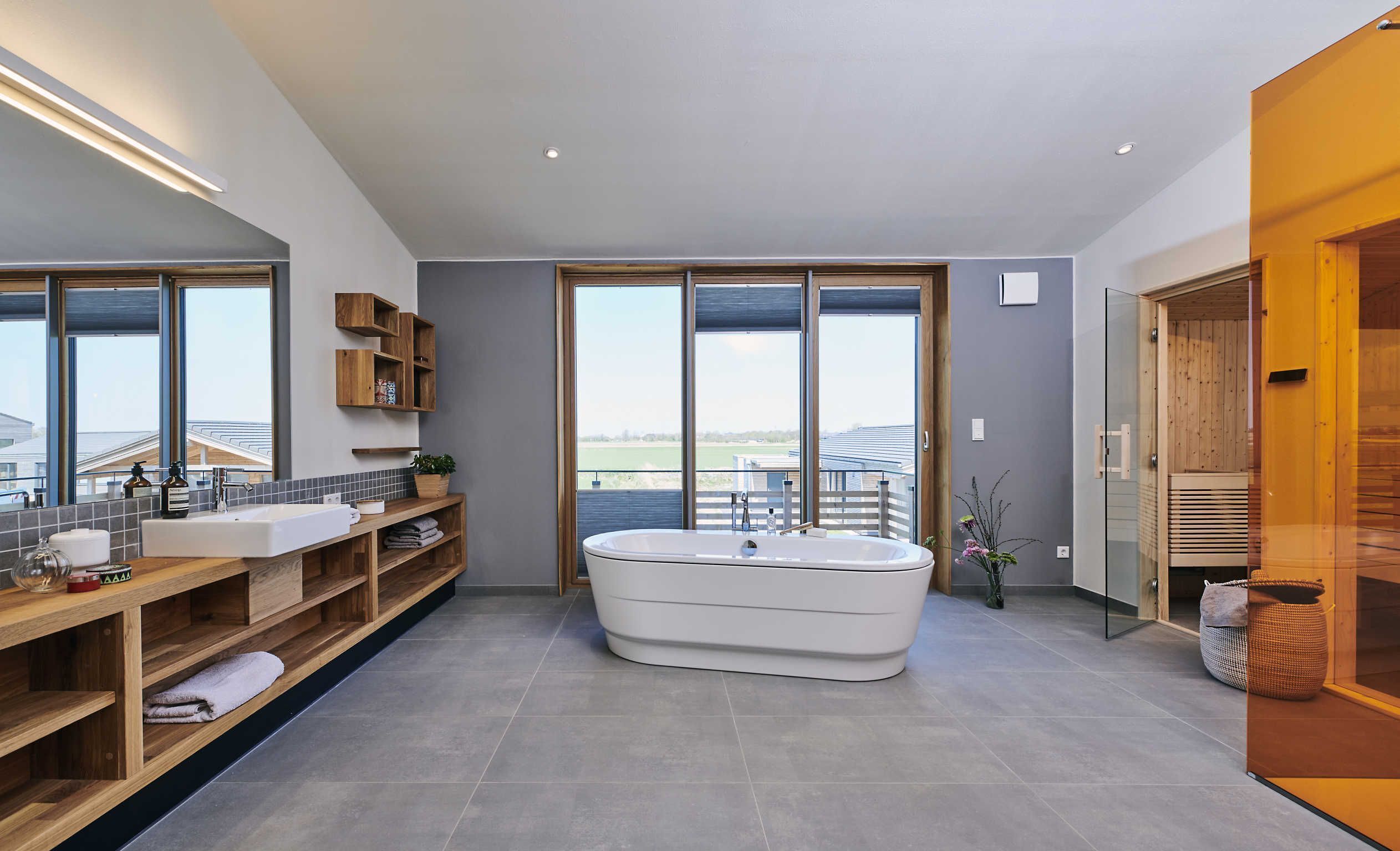 A modern bathroom with a freestanding bathtub, wooden shelves, and a large window offering a view of the outdoors.