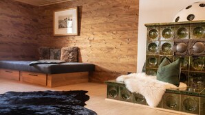 Una habitación acogedora con pared de madera, una cama con almohada mullida, un mueble verde con diseños circulares y una alfombra peluda negra.