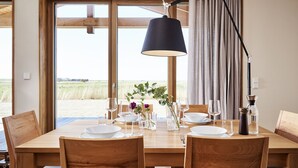 A dining table set with plates, glasses, and a vase with flowers. - (03) Gud Jard Lodge Leo, Cat. FamilyTime - Designer holiday home Leo (03) with (Pellworm)