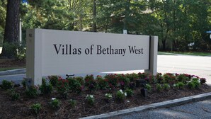 Señal de Villas de Bethany West con un parterre de flores al frente.