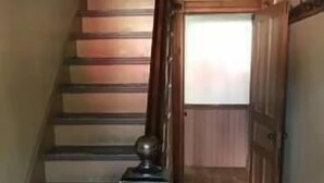A staircase with wooden steps and a handrail, leading to a door with a window. - Charming home in the heart of Rockland, Charming home in the heart of Rockland (Rockland)
