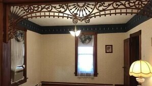 A room with a wooden floor, a window with a curtain, a door, and a lamp on a table. - Charming home in the heart of Rockland, Charming home in the heart of Rockland (Rockland)