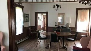 A dining area with a round table and chairs, a chandelier, and a view of the kitchen through an open doorway. - Charming home in the heart of Rockland, Charming home in the heart of Rockland (Rockland)