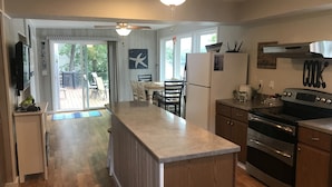A kitchen with a central island, wooden cabinets, a built-in oven, and a refrigerator. - Single level home in a gentle, quiet , deep water cove  at Lake of the Ozarks . (Roach)