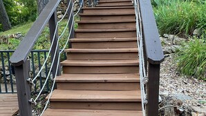 A wooden staircase with metal railings leading to a covered area. - Single level home in a gentle, quiet , deep water cove  at Lake of the Ozarks . (Roach)