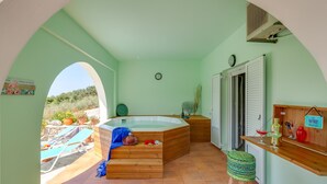 A room with a wooden hot tub, a bar area, and a view of an outdoor swimming pool. - Villa Kallisti-Artemis - A terrestrial paradise! (Georgioupolis, Chania)