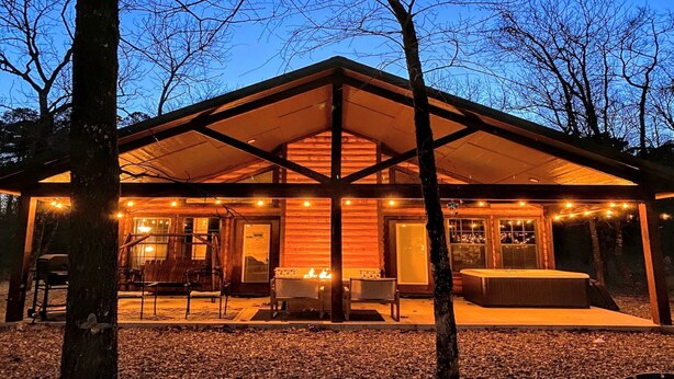 A rustic cabin with a covered patio, fire pit, and seating area. - The Blue Heron, HIDDEN IN THE WOODS YET CLOSE TO TOWN (Broken Bow)