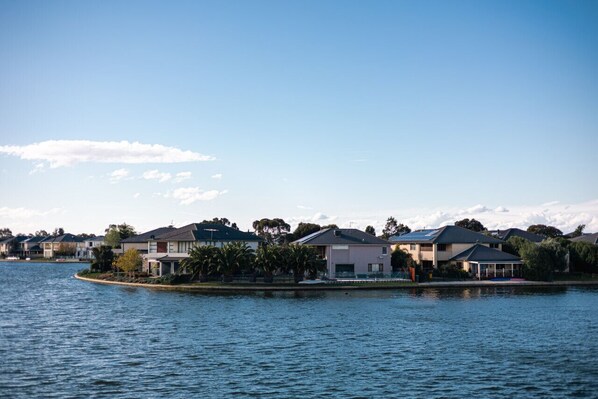 A lakeside residential area with houses, some with attached garages, and a clear sky.