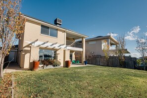 A two-story house with a covered patio, a garage, and a fenced yard.
