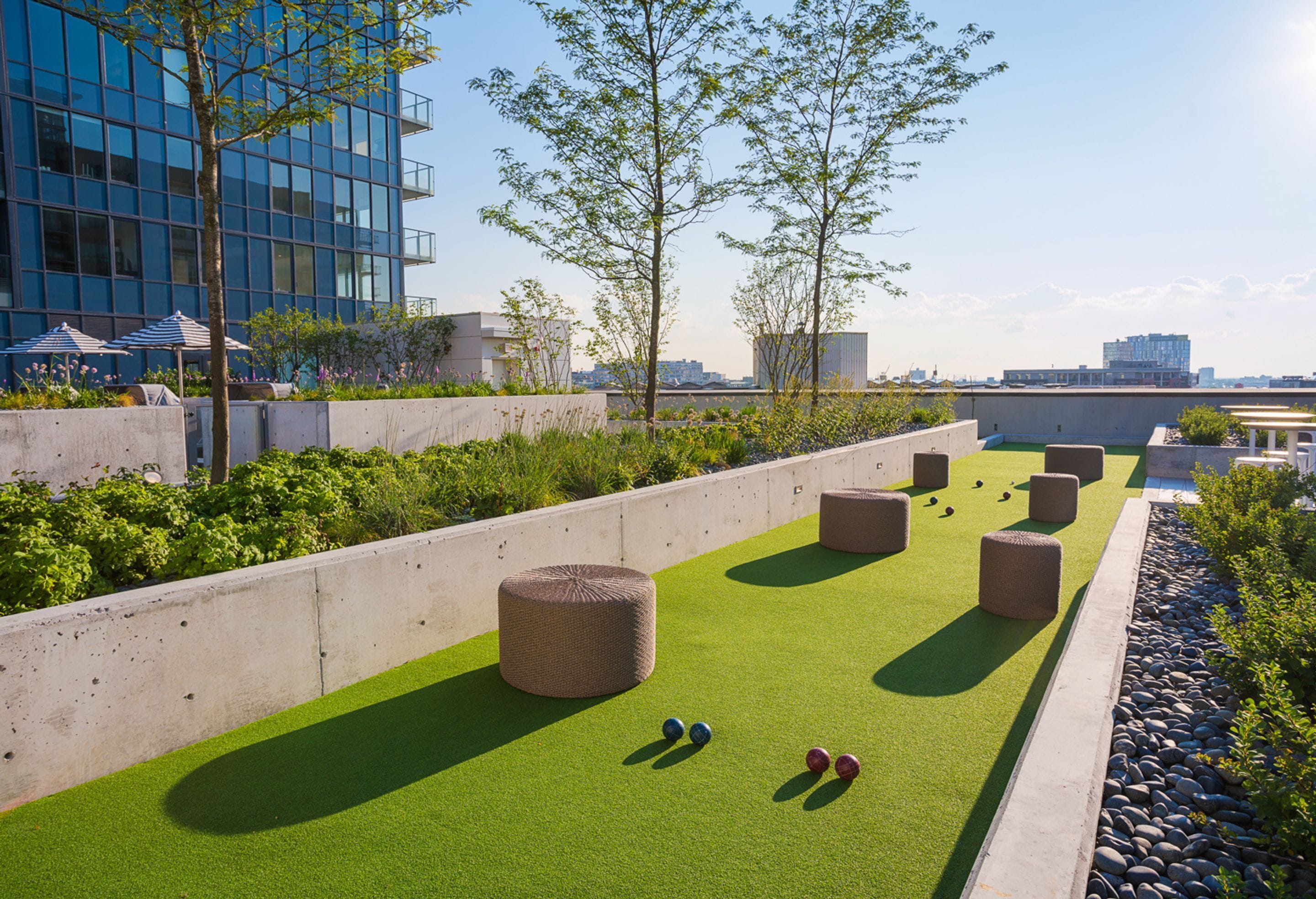 A rooftop with artificial turf, outdoor seating, and a view of the cityscape.