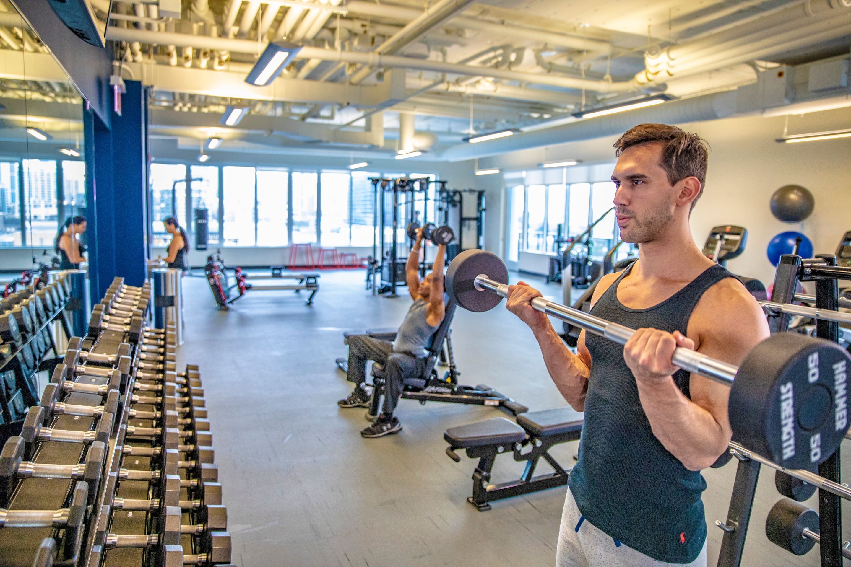 A gym with weightlifting equipment, benches, and various exercise machines.