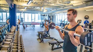 A gym with weightlifting equipment, benches, and various exercise machines.