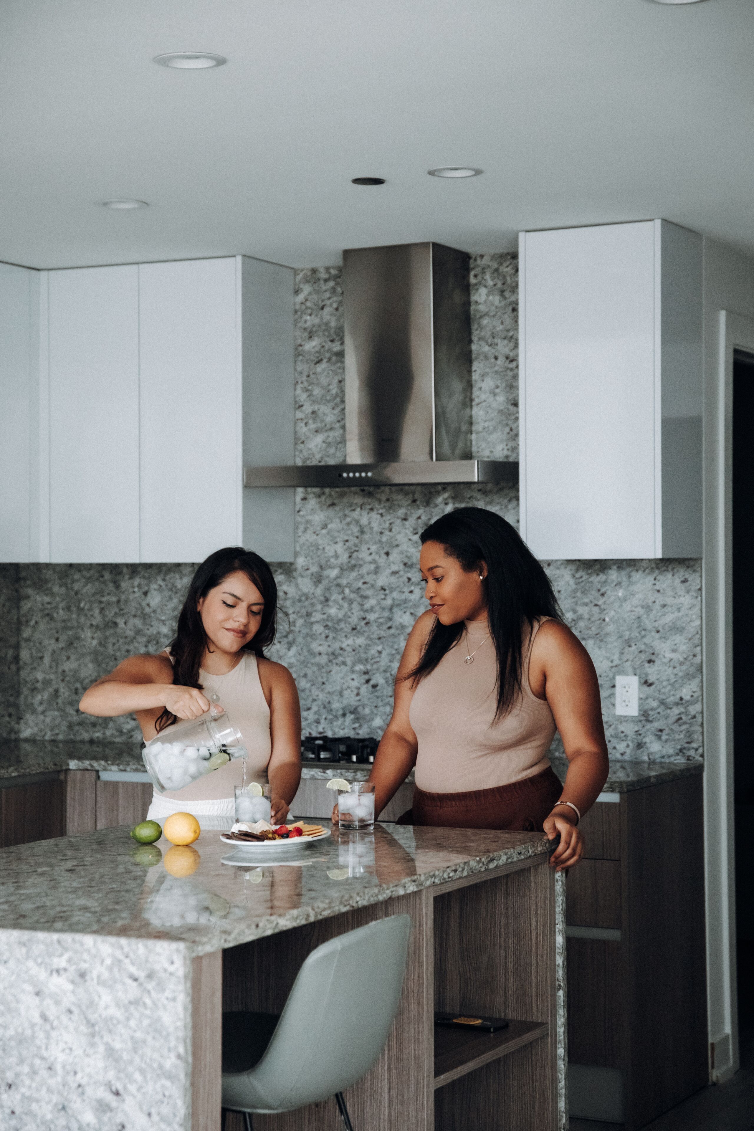 A modern kitchen with white cabinets, a granite countertop, and stainless steel appliances.