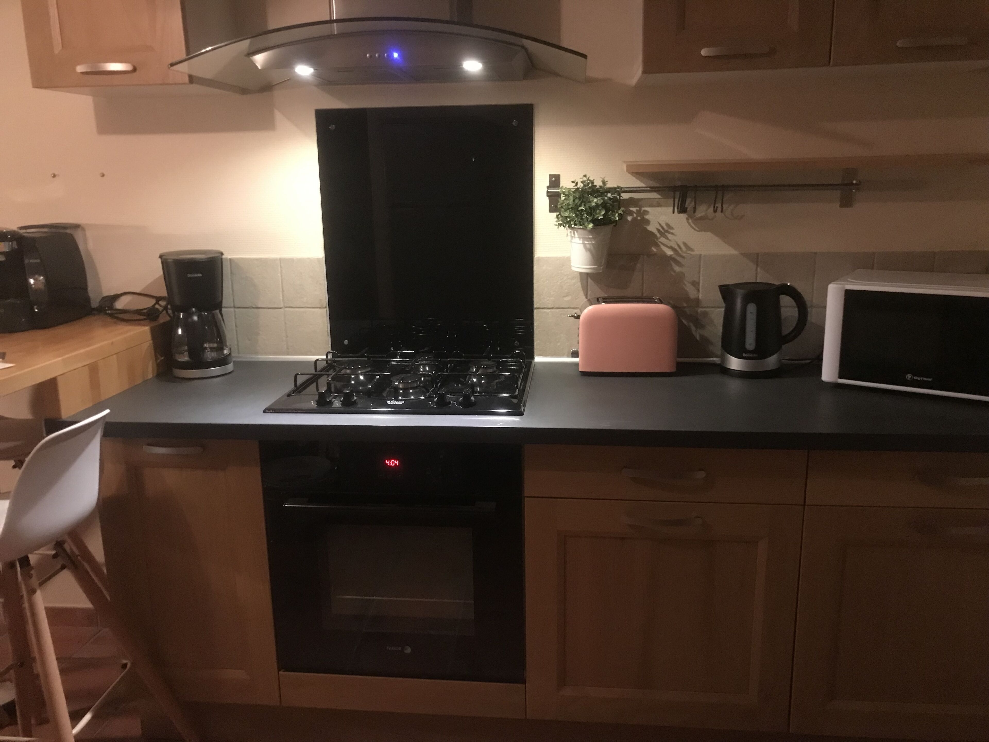 A kitchen with a black stove, a microwave, a toaster, and a coffee maker.