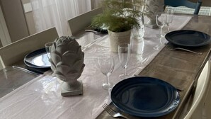 Ett matbord dukat med blå tallrikar, vita servetter och klara vinglas.
