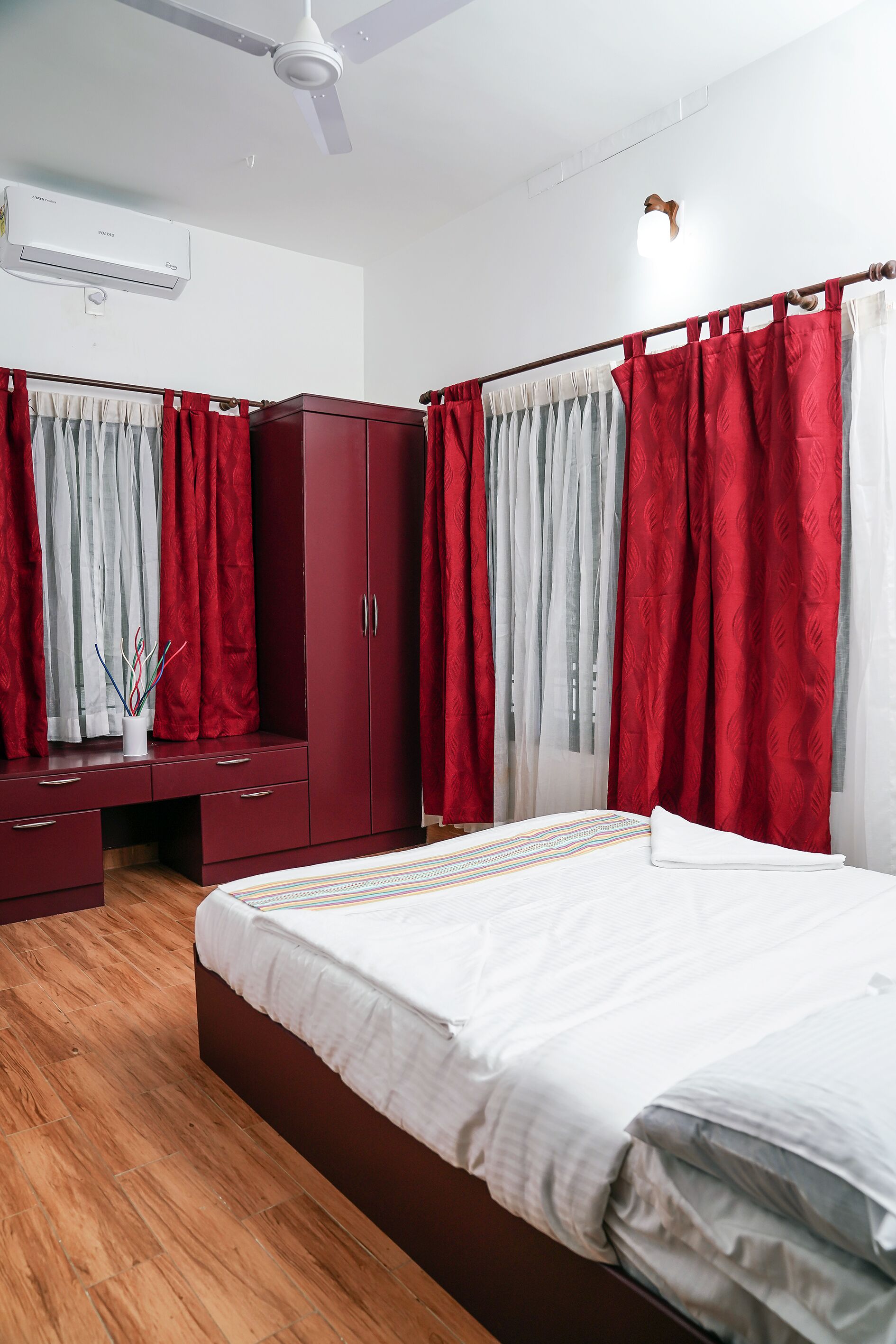 A bedroom with a bed, a wardrobe, and a desk with a chair.