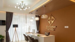A modern hotel lobby with a reception desk, seating area, and a decorative wall. - One Vientiane Hotel & Restaurant (Vientiane)